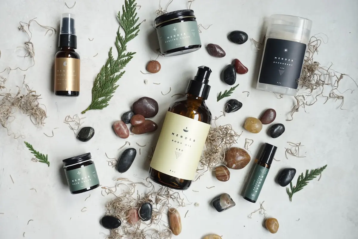 Small batch apothecary bottles arranged with botanicals and river stones