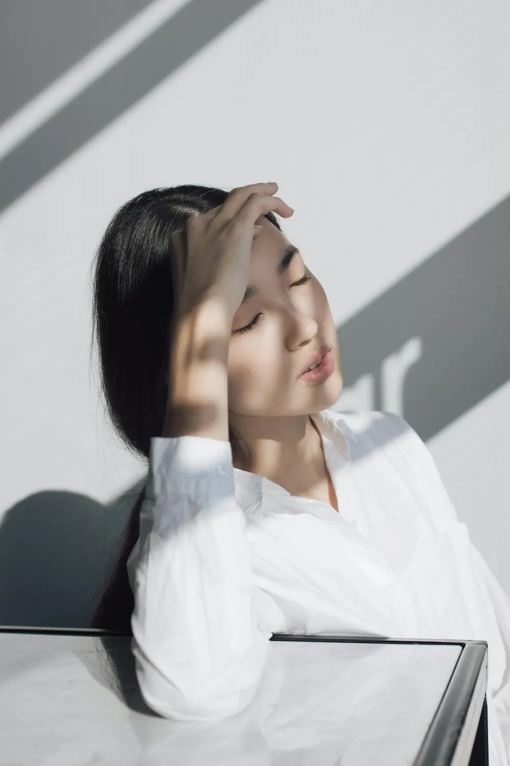 Woman resting with her eyes closed in soft morning sunlight