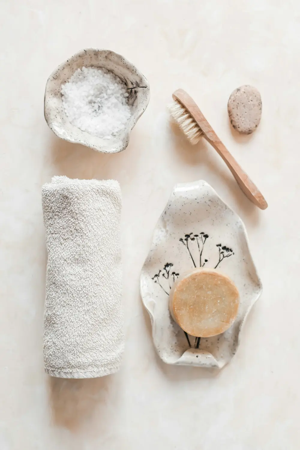 Considered arrangement of natural spa objects, towel and wooden tools in warm neutral tones